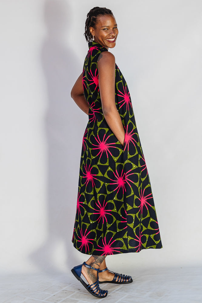 Model wearing navy and green dress with pink floral print.