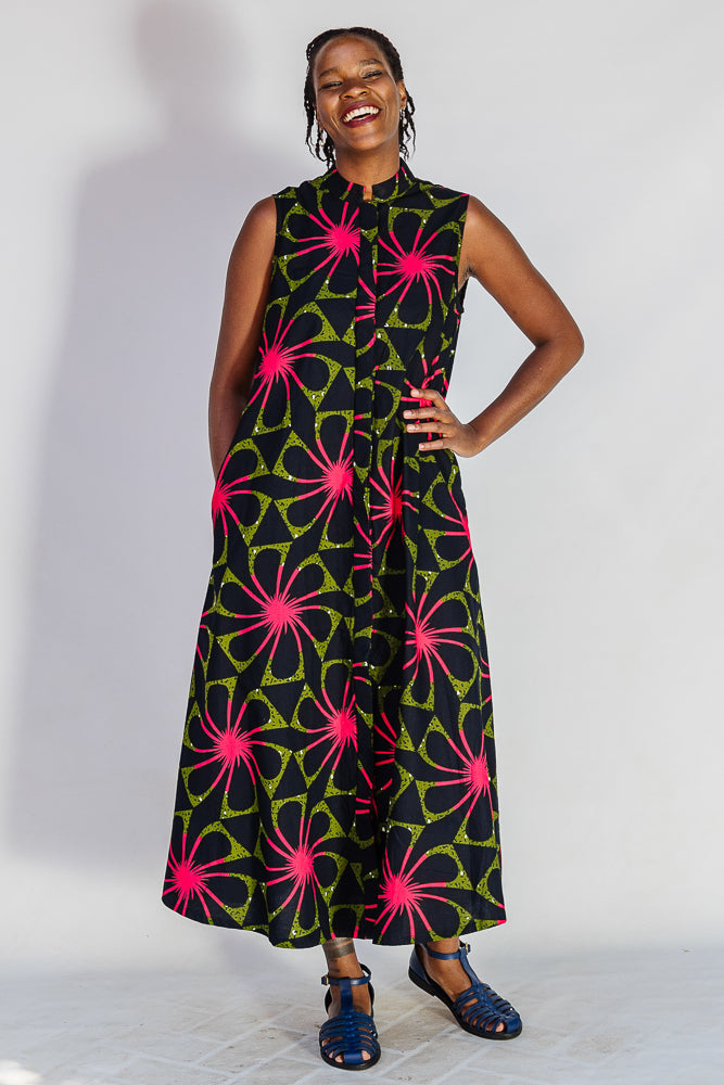 Model wearing navy and green dress with pink floral print.