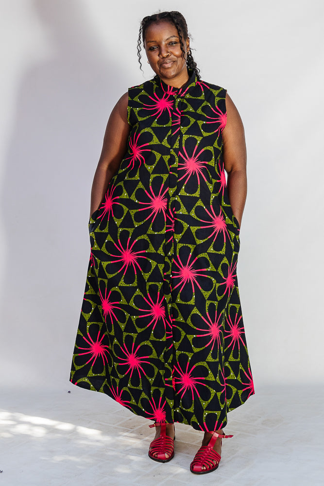 Model wearing navy and green dress with pink floral print.