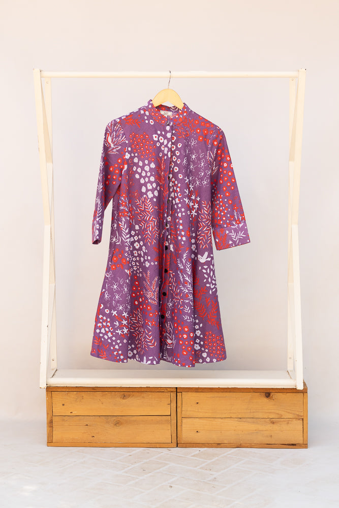 Display of purple dress with red and white floral print.