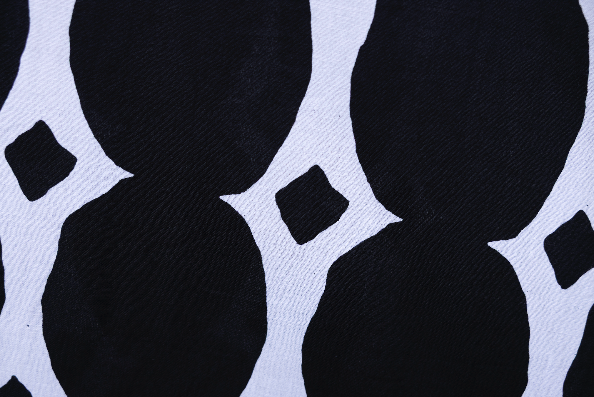 Close up display of black and white geometric print dress, fabric.