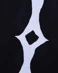 Close up display of black and white geometric print dress, fabric.