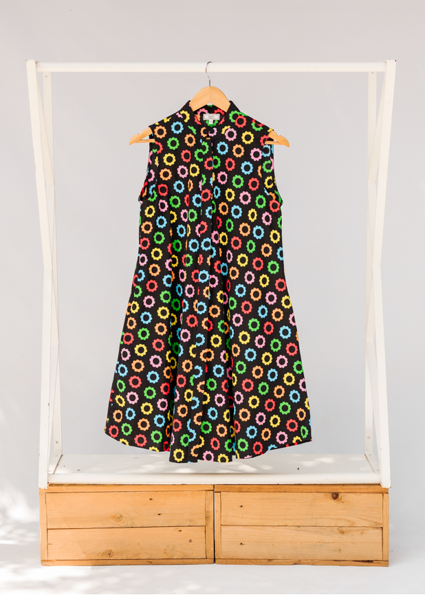 Display of black sleeveless dress with rainbow circle print.