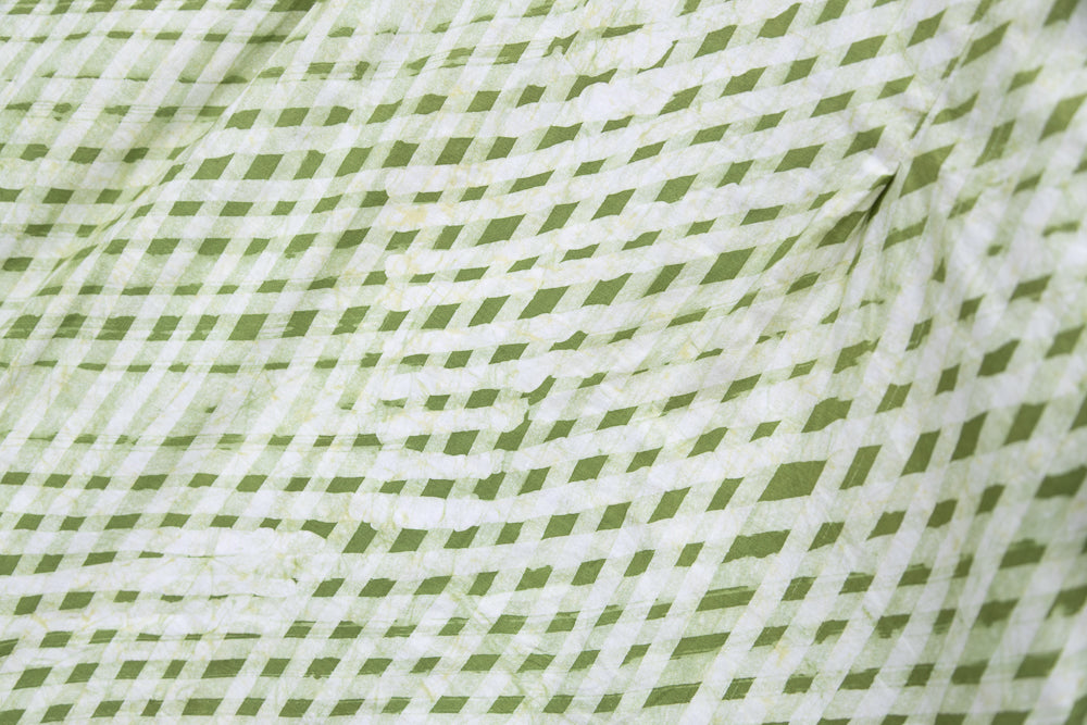 Close up display of green and white plaid shirt, fabric.