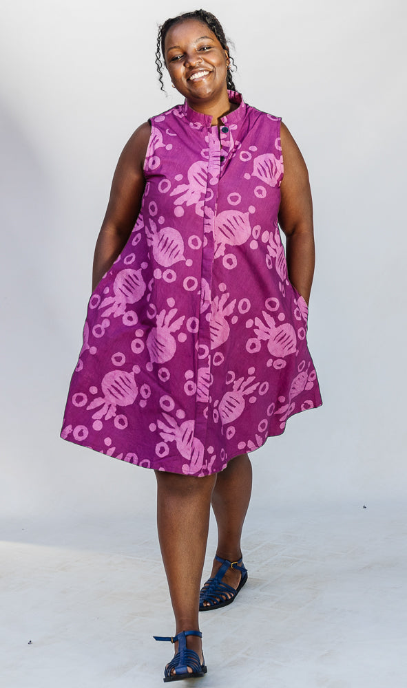 Model wearing purple dress with pink beet print.