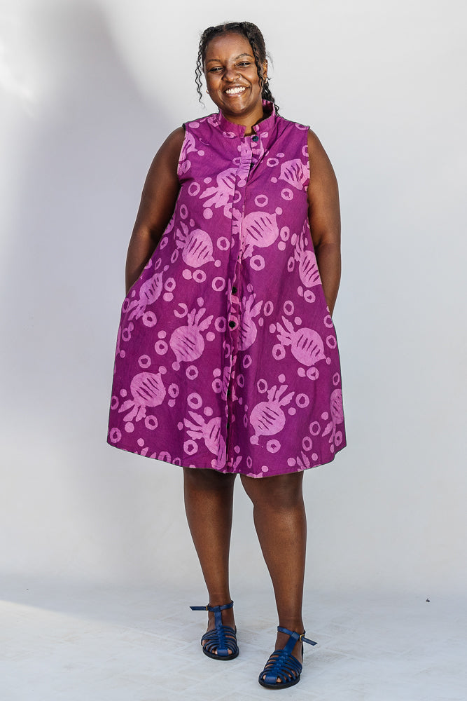 Model wearing purple dress with pink beet print.
