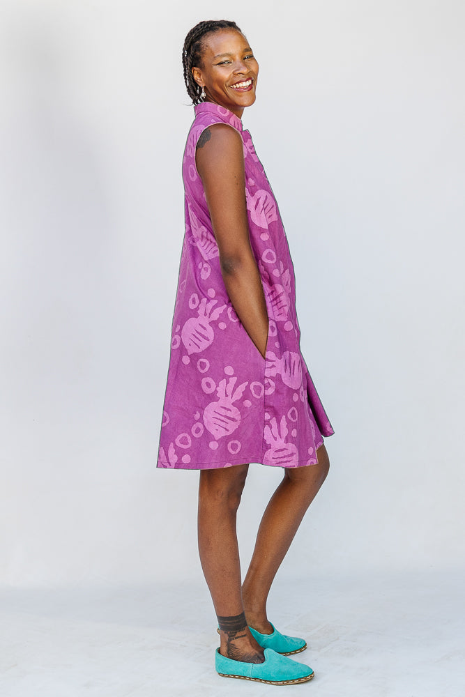 Model wearing purple dress with pink beet print.
