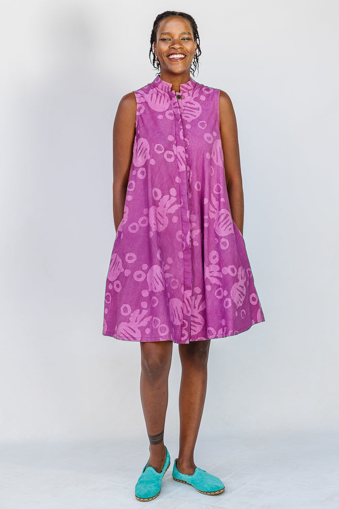 Model wearing purple dress with pink beet print.