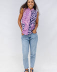 Model wearing purple, pink and white geometric print, patchwork sleeveless shirt.