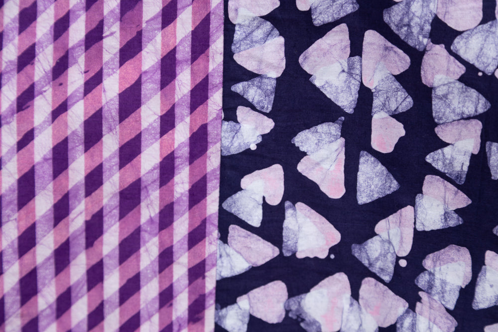Close up display of purple, pink and white geometric print, patchwork sleeveless shirt, fabric.