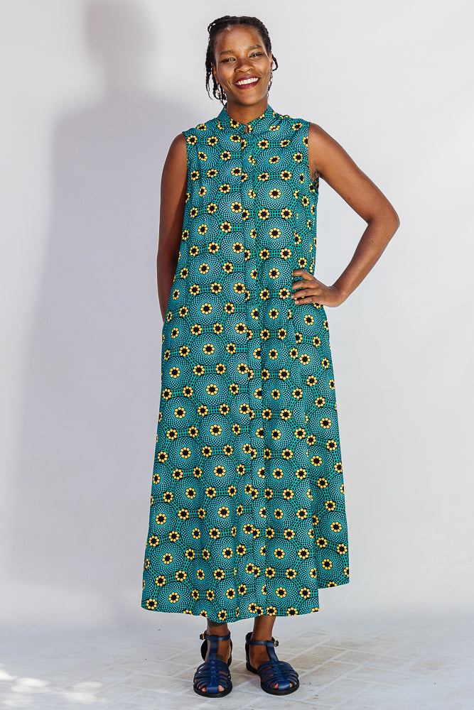 Model wearing teal dress with yellow sunflower print.