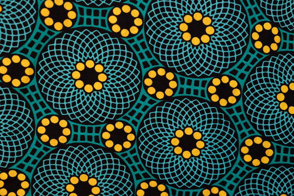 Close up display of teal dress with yellow sunflower print, fabric.