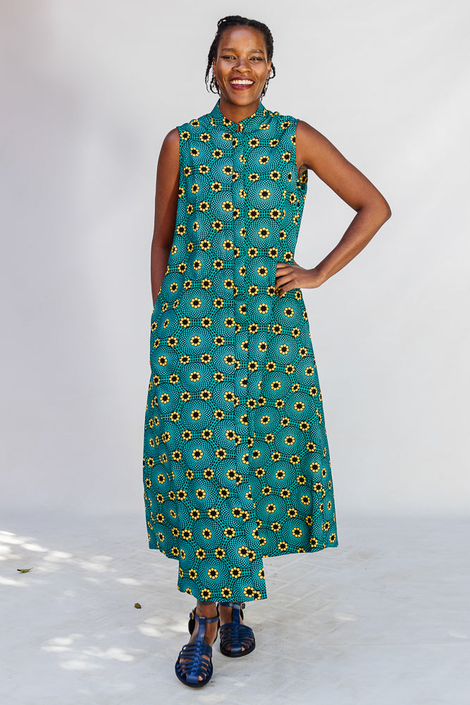 Model wearing teal dress with yellow sunflower print.