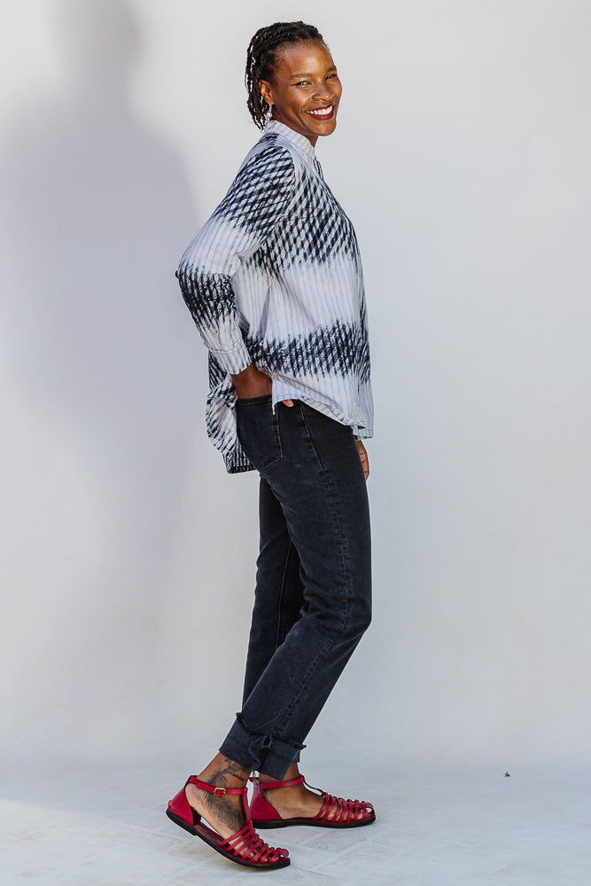 Model wearing white and black batik shirt.