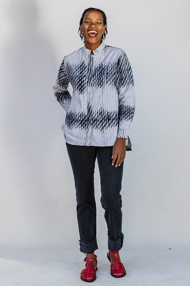 Model wearing white and black batik shirt.