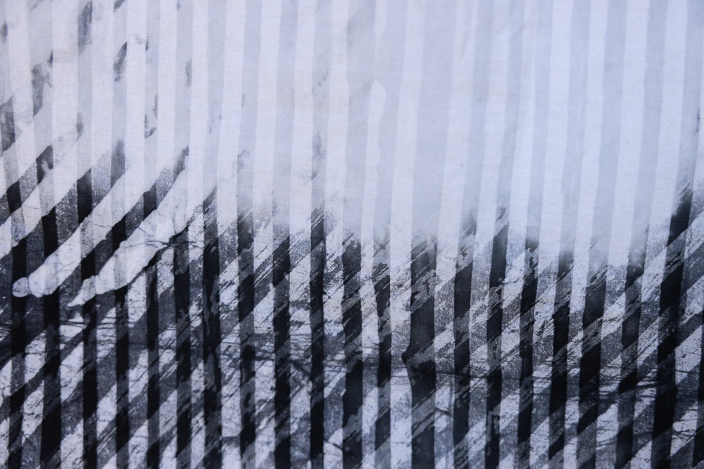 Close up display of white and black batik shirt, fabric.