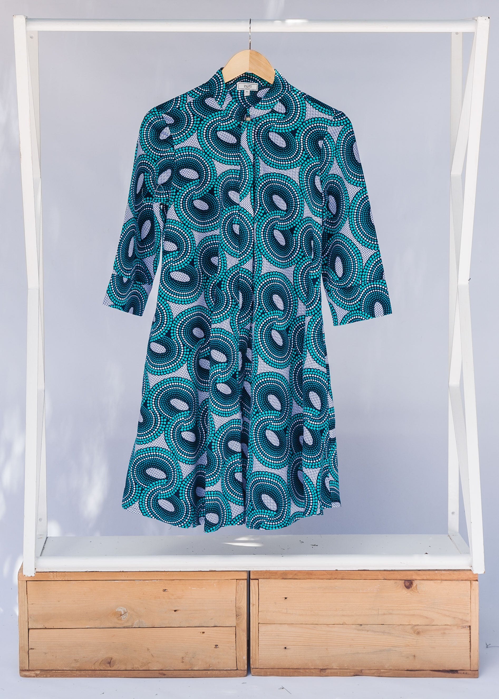 Display of dress with teal shaded loop print.