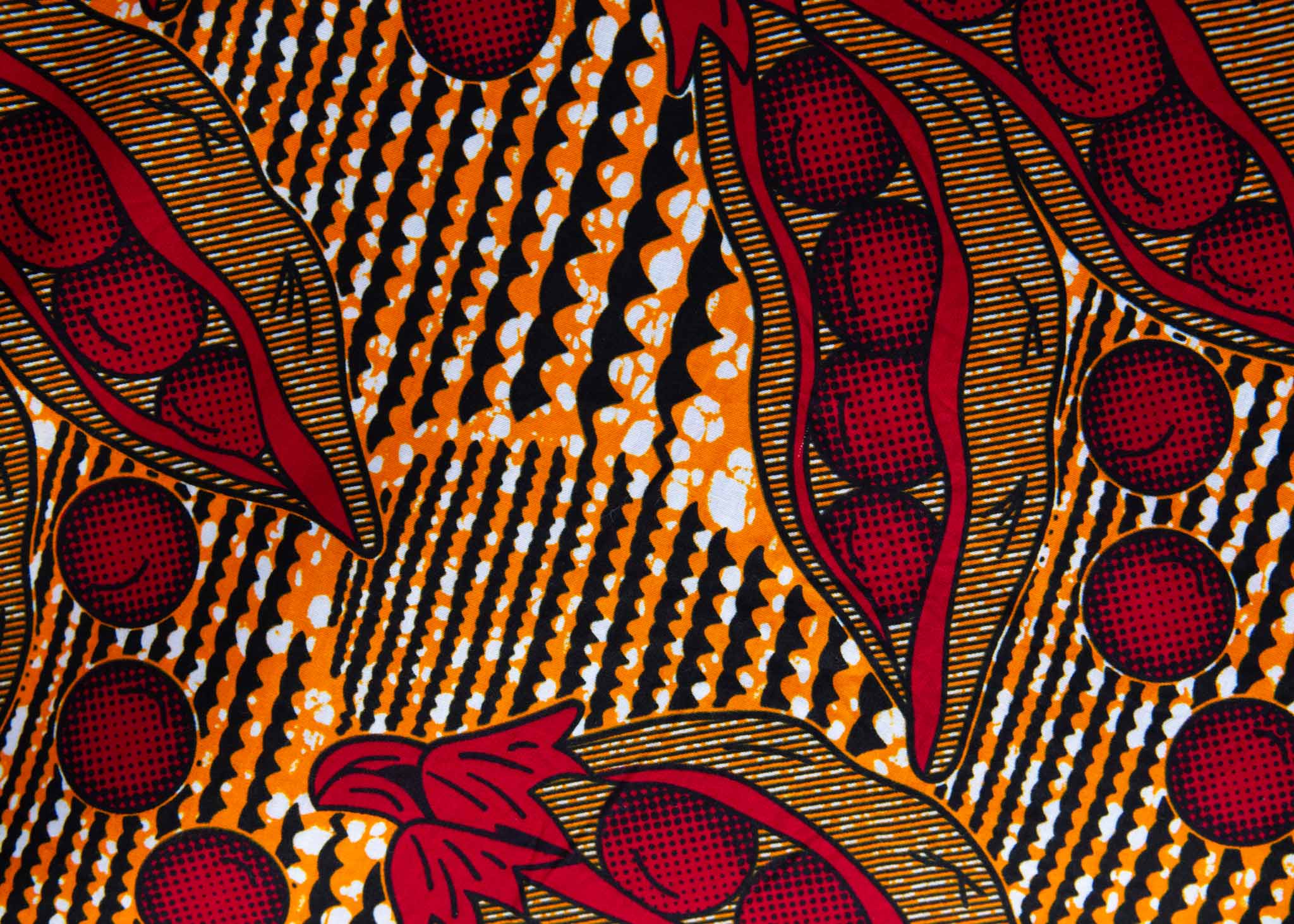 Close up display of brown dress with red snap pea print, fabric.