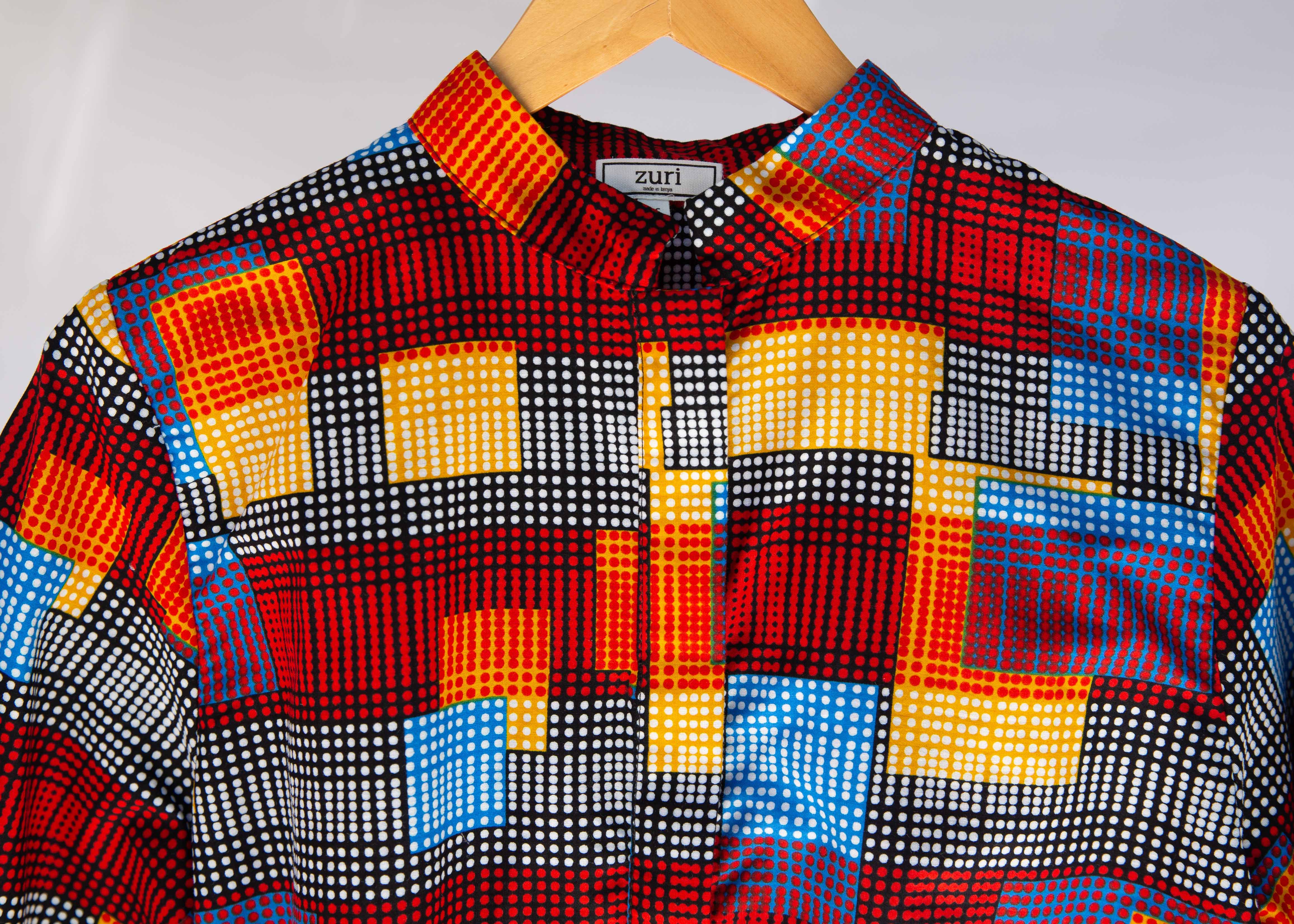 Display of rainbow dot print long sleeve shirt.
