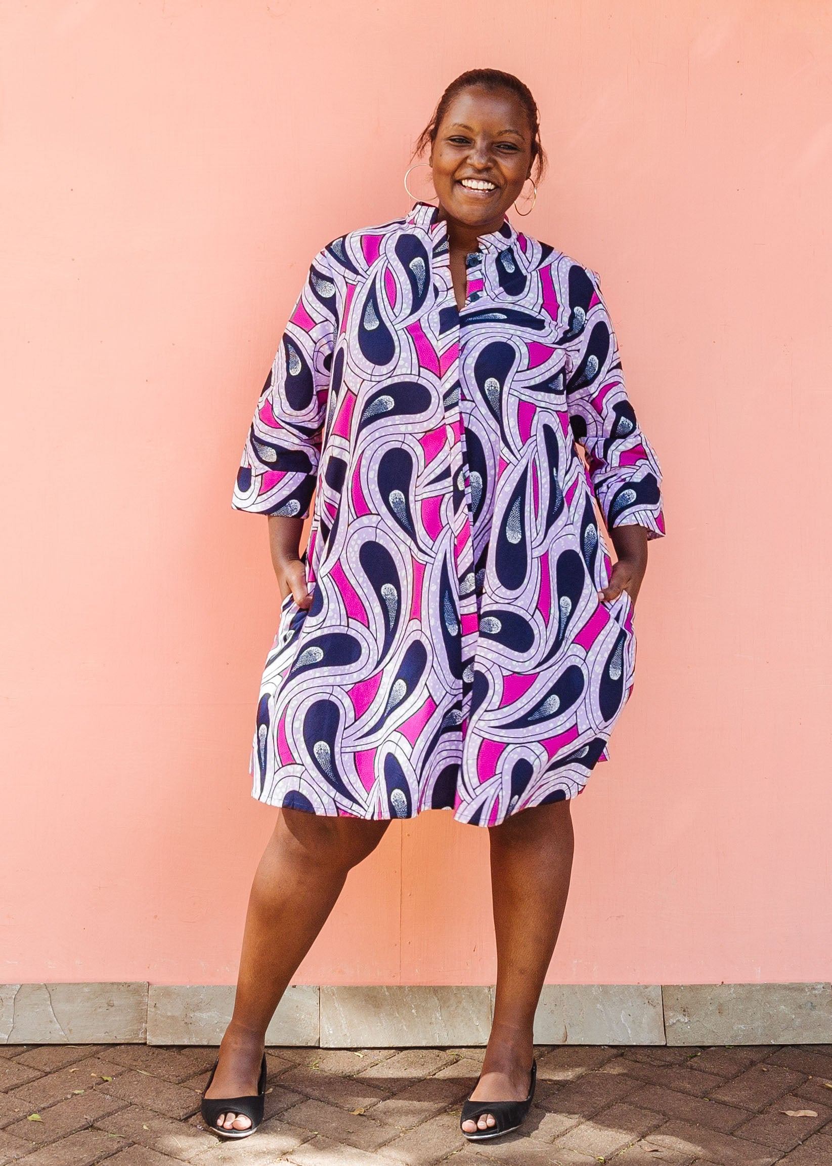 Model wearing purple and pink geometric print dress.