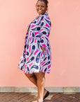 Model wearing purple and pink geometric print dress.