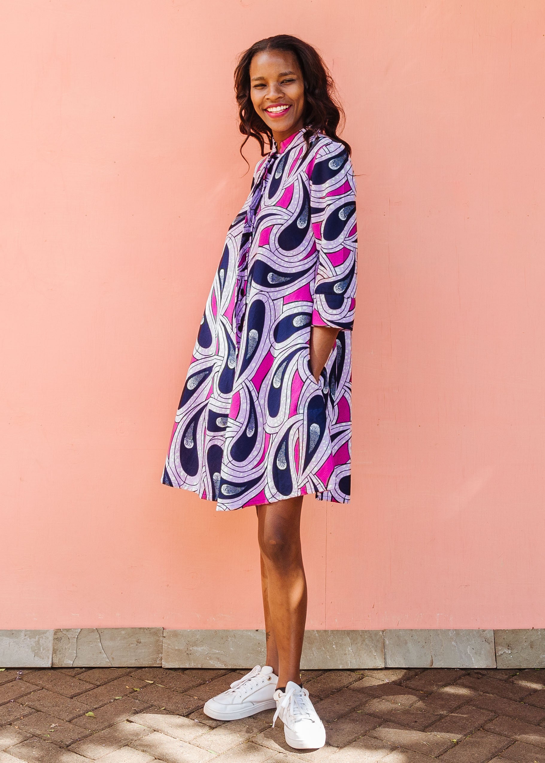 Model wearing purple and pink geometric print dress.