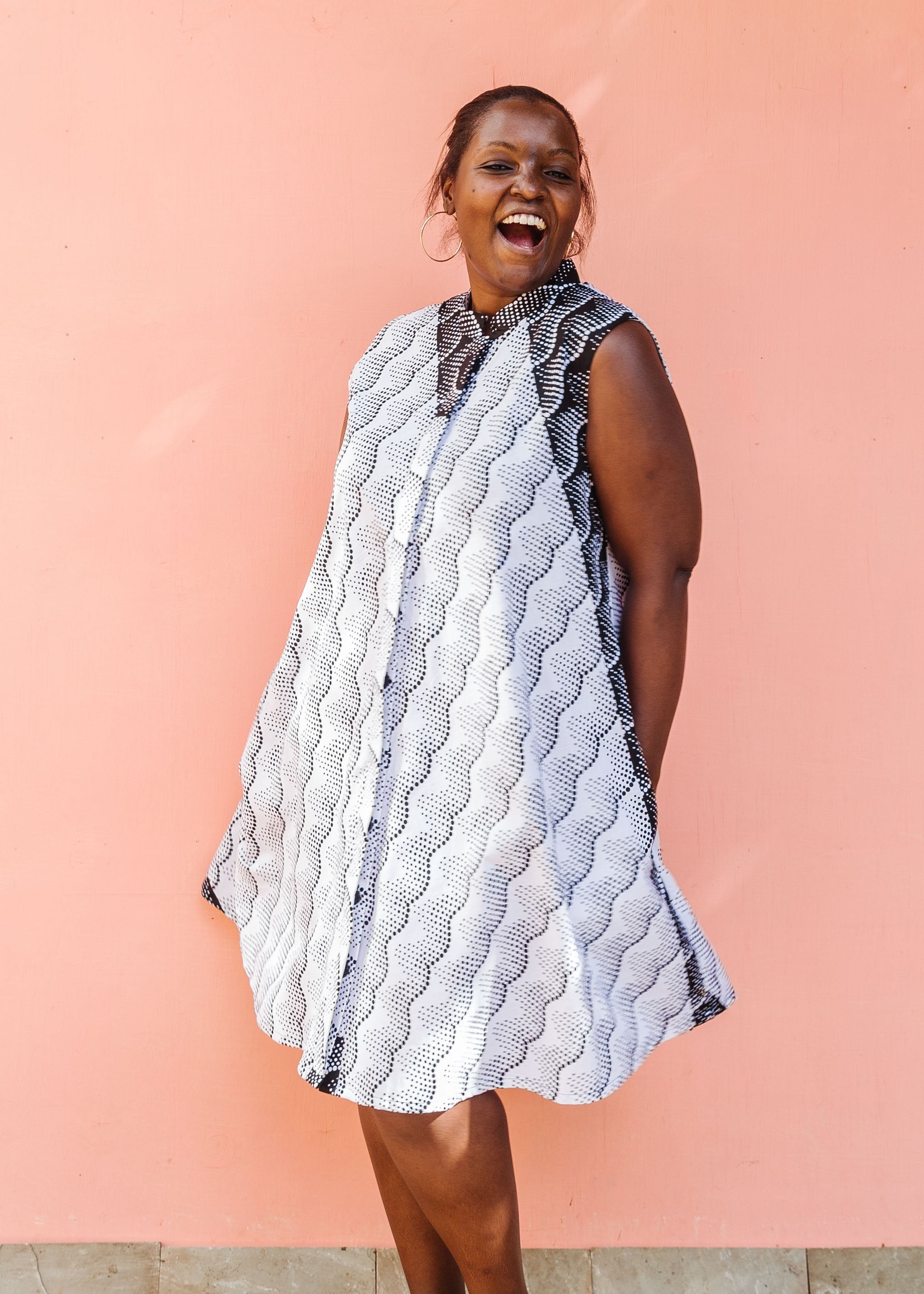 Model wearing black and white sleeveless dress.