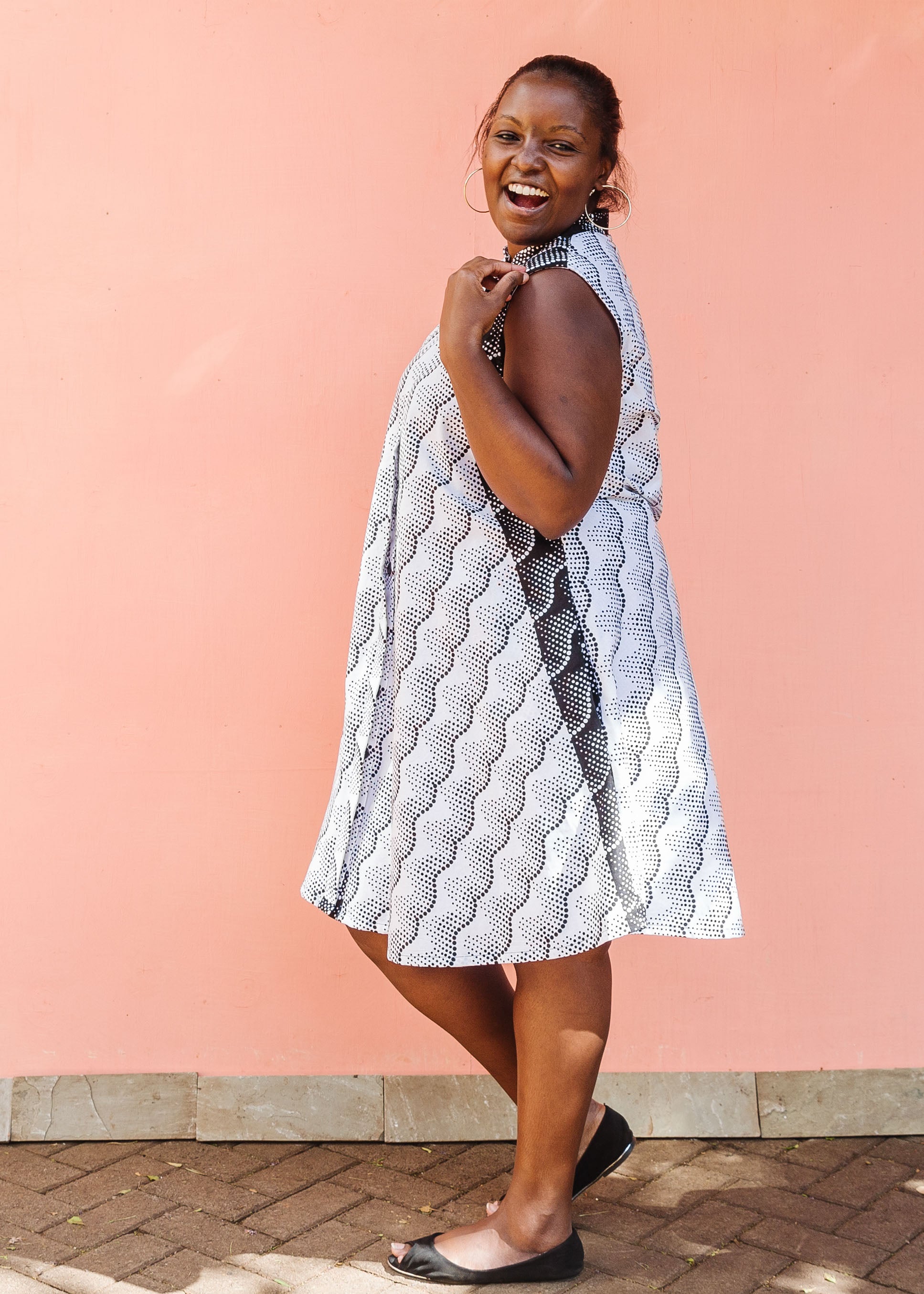 Model wearing black and white sleeveless dress.