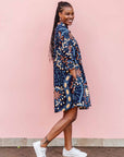 The model is wearing navy blue dress with yellow, white, brown and sky blue floral print 