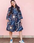 The model is wearing navy blue dress with yellow, white, brown and sky blue floral print 