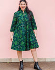 The model is wearing black and forest green dress with lime green and white floral print