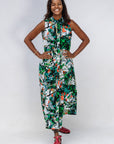 Model wearing dress with green, grey, white, orange and black abstract print.