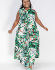 Model wearing dress with green, grey, white, orange and black abstract print.