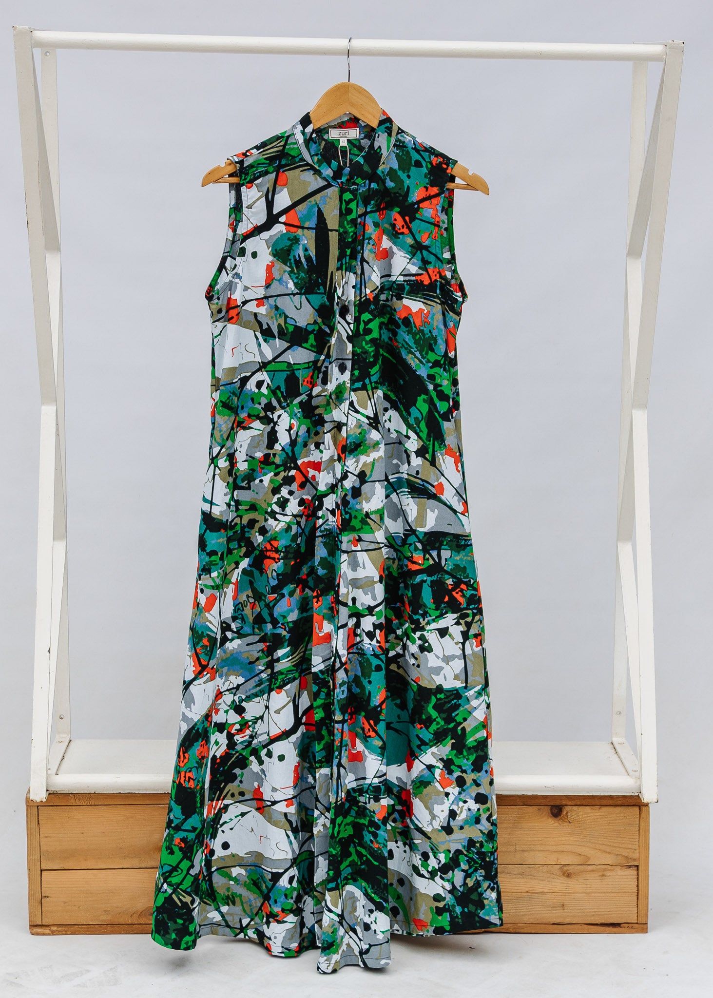 Display of dress with green, grey, white, orange and black abstract print.