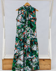 Display of dress with green, grey, white, orange and black abstract print.
