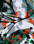 Close up display of dress with green, grey, white, orange and black abstract print, fabric.