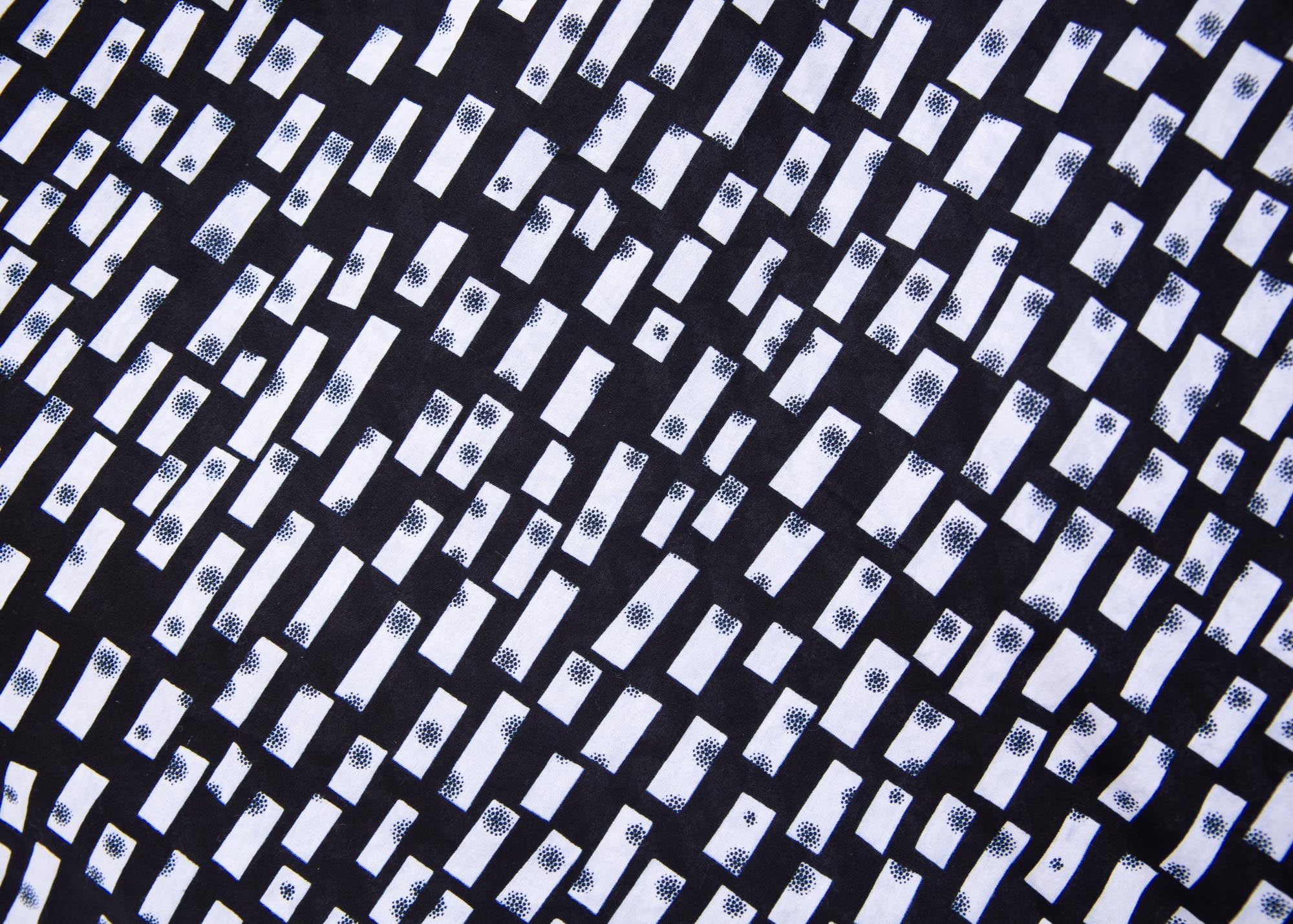 Close up display of black dress with white rectangles
