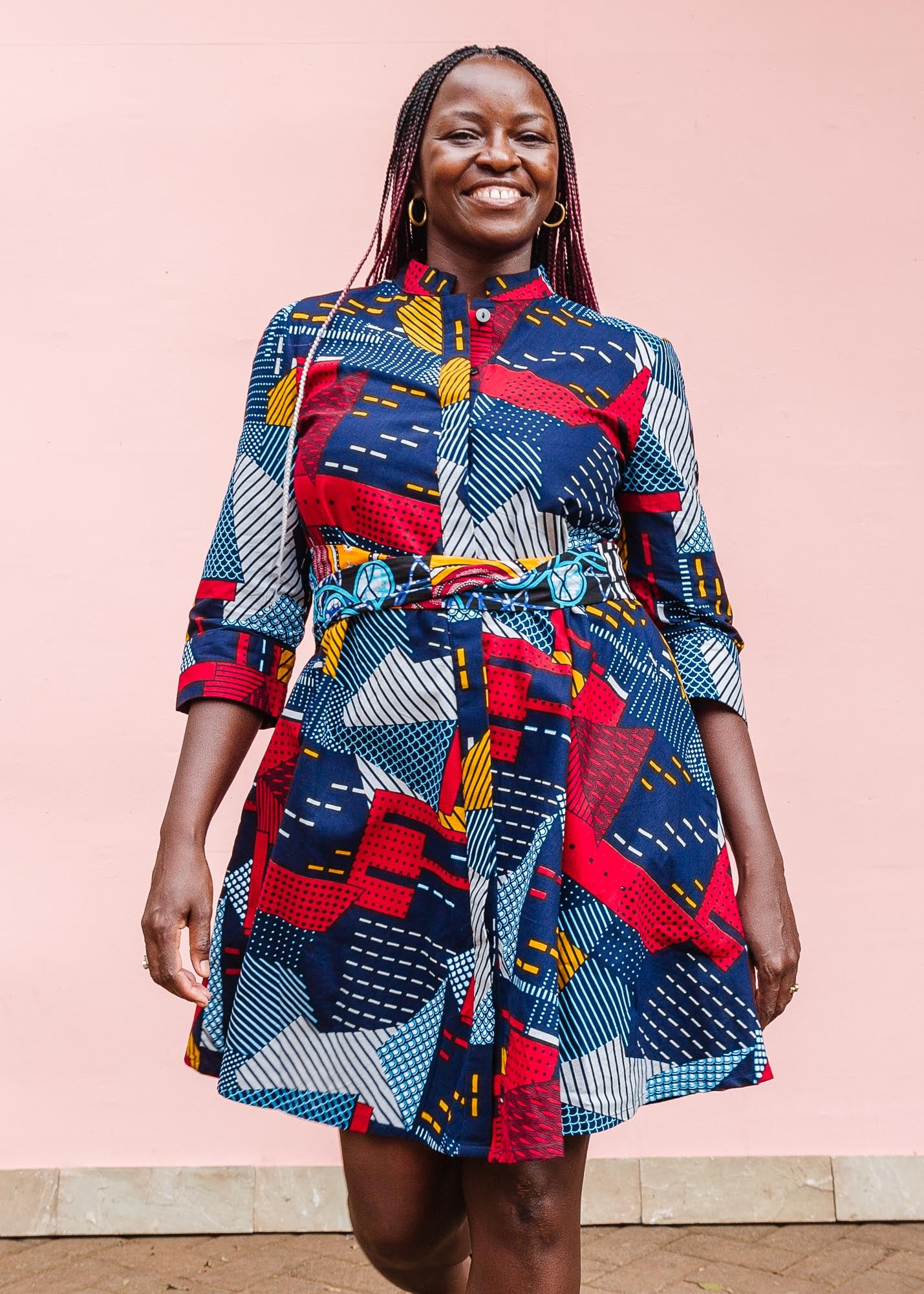 The model is wearing multi-colored geometric print dress