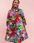 The model is wearing multi-colored leaf print dress