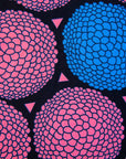 Close up display of coral, blue and black circular print dress