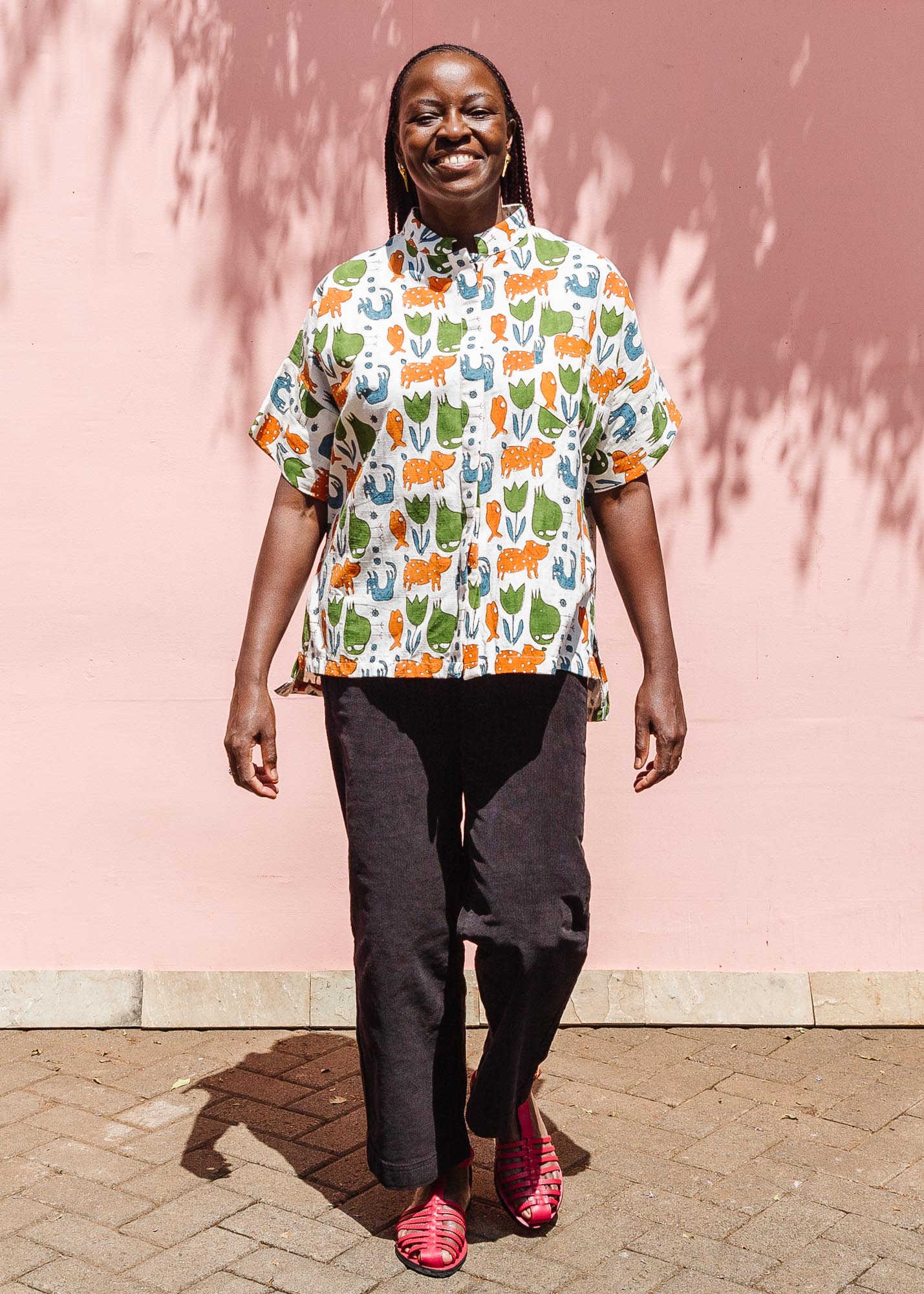 The model is wearing blue, orange, green, brown, white and black print shirt