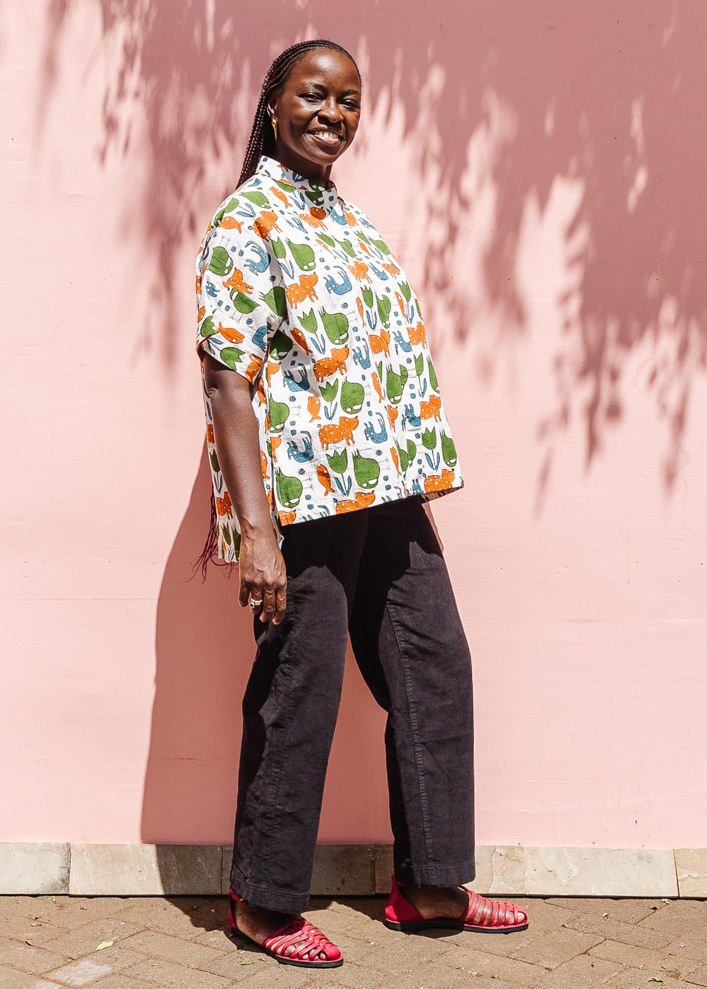 The model is wearing blue, orange, green, brown, white and black print shirt