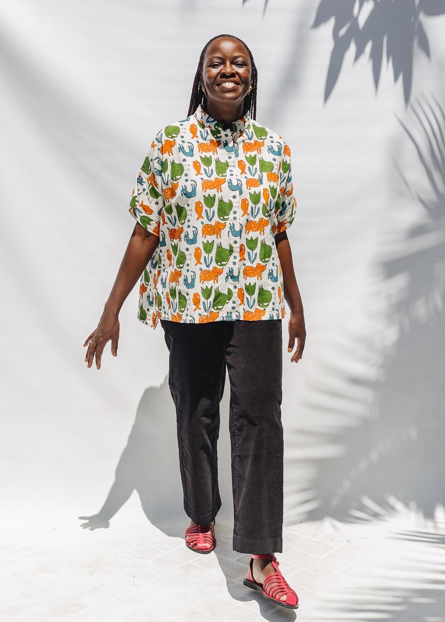 The model is wearing blue, orange, green, brown, white and black print shirt