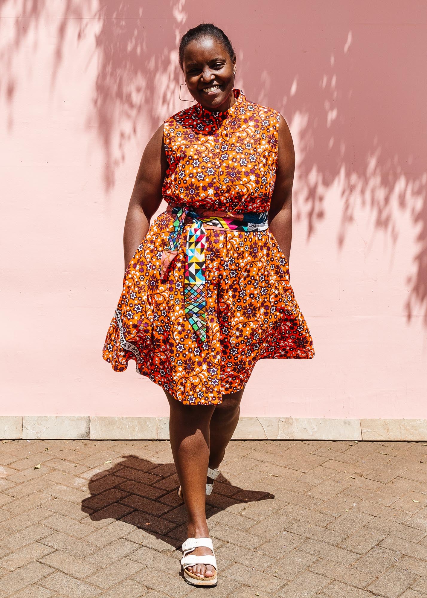 The model is wearing multi-colored floral print dress