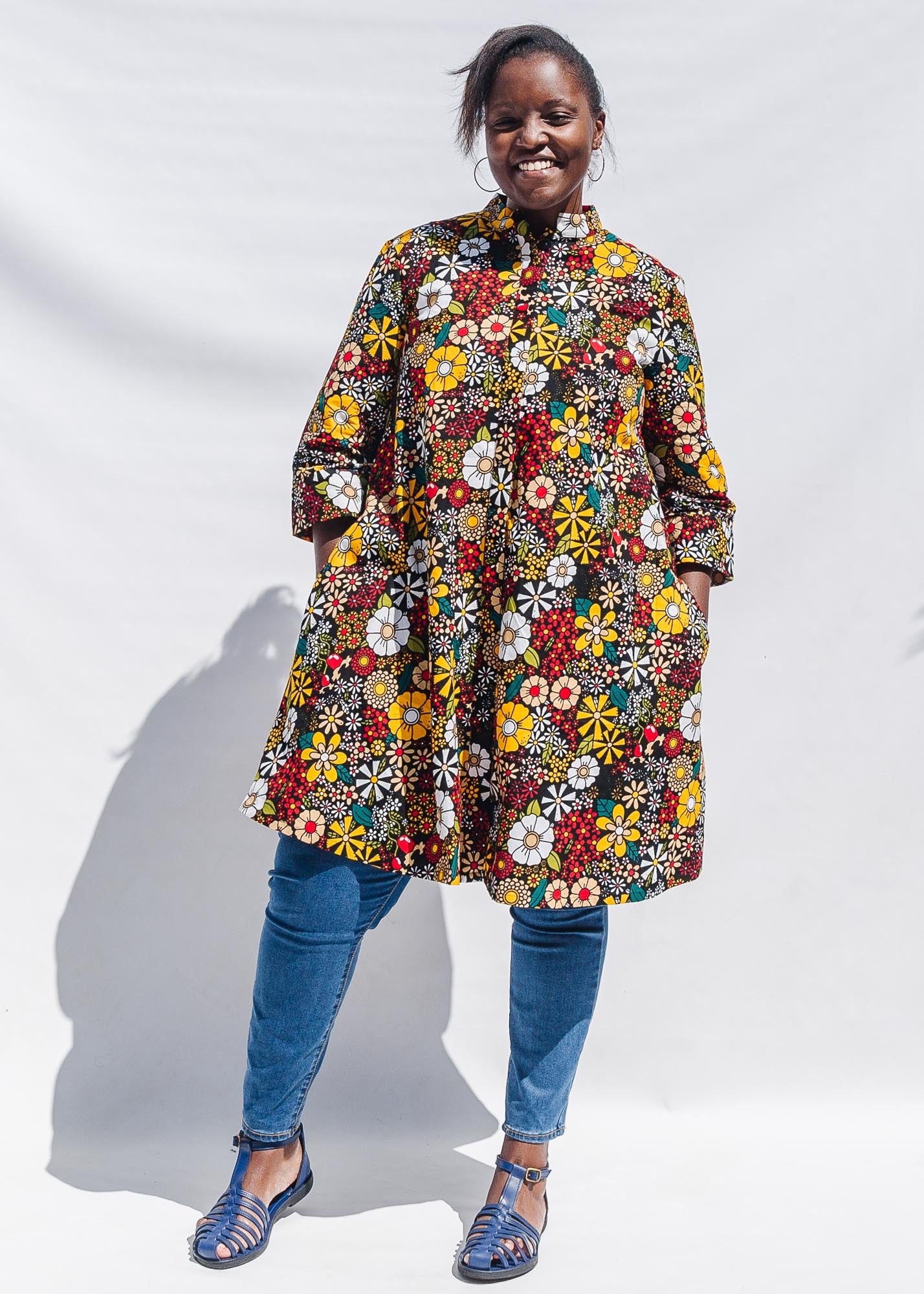 The model is wearing colorful flower print dress