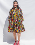 The model is wearing colorful flower print dress