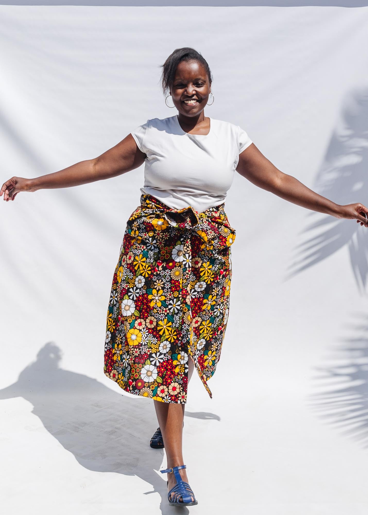 The model is wearing colorful flower print dress