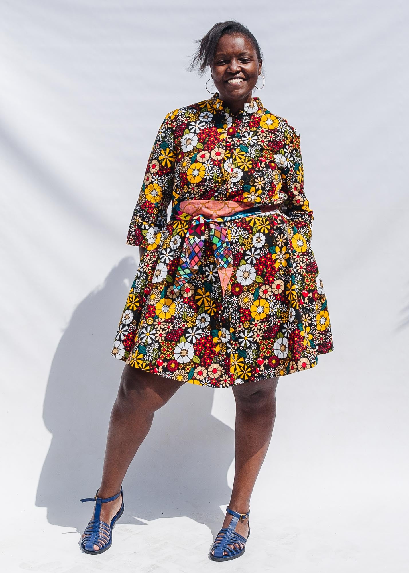 The model is wearing colorful flower print dress