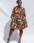 The model is wearing colorful flower print dress