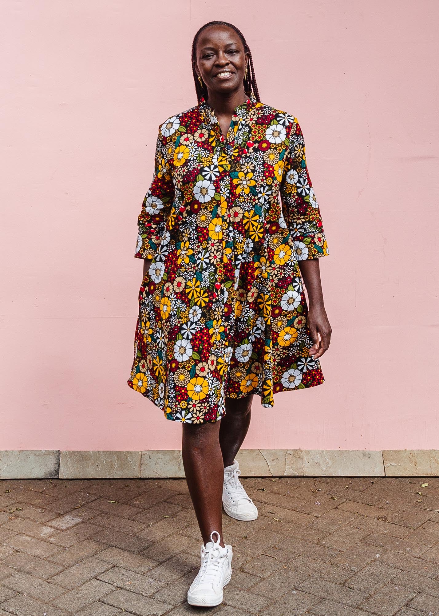 The model is wearing colorful flower print dress